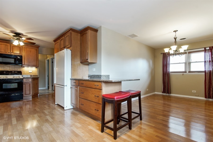 847 Heritage Drive, Unit 1 Addison, IL 60101 - Photo 4 of 10 a kitchen with stainless steel appliances kitchen island granite countertop a refrigerator stove top oven and sink