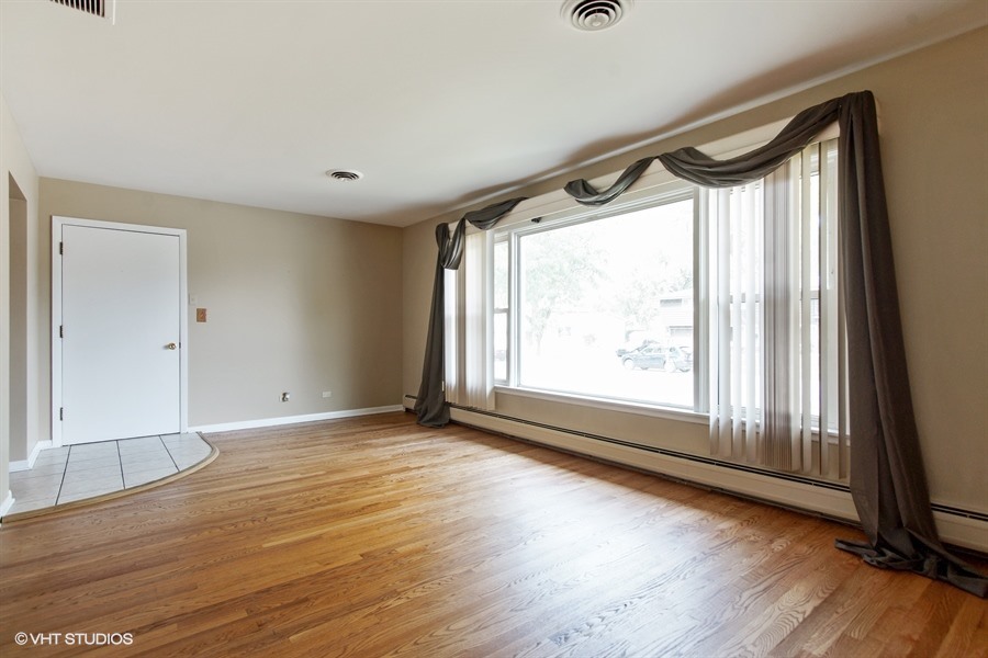847 Heritage Drive, Unit 1 Addison, IL 60101 - Photo 6 of 10 a view of an empty room with wooden floor and a window