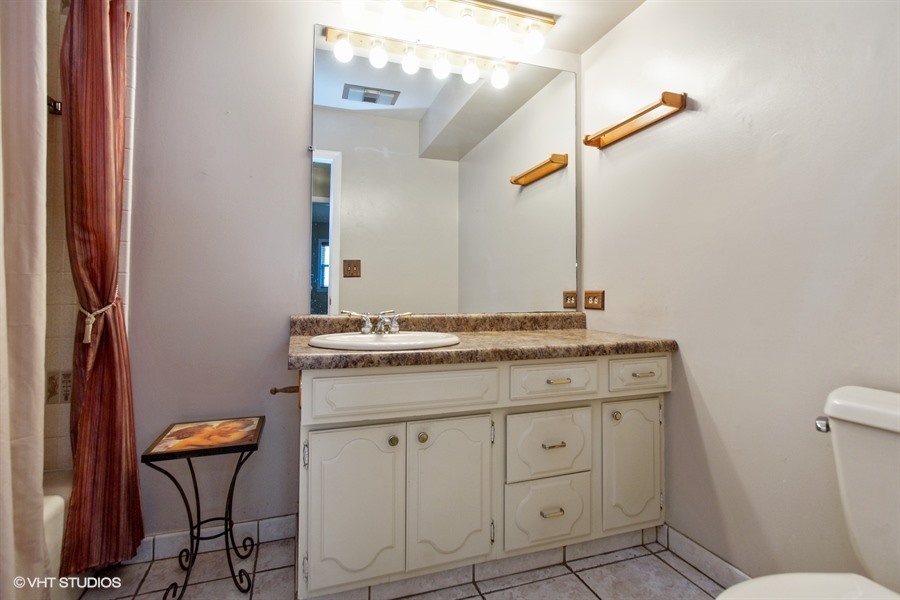 847 Heritage Drive, Unit 1 Addison, IL 60101 - Photo 8 of 10 a bathroom with a granite countertop sink and a mirror