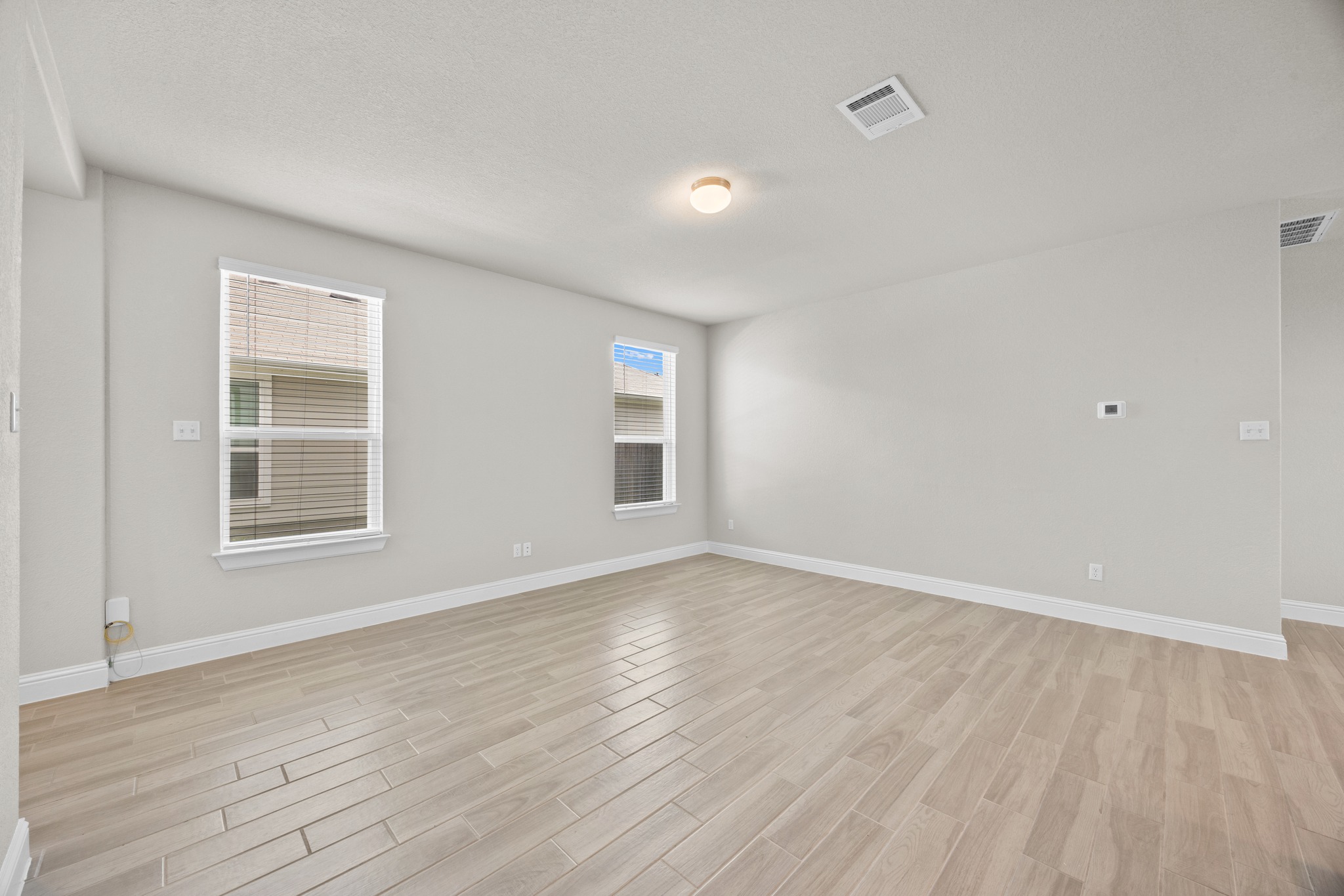 213 Graver Street Georgetown, TX 78626 - Photo 6 of 33 A spacious room offers light-colored wood-look flooring and ample wall space.