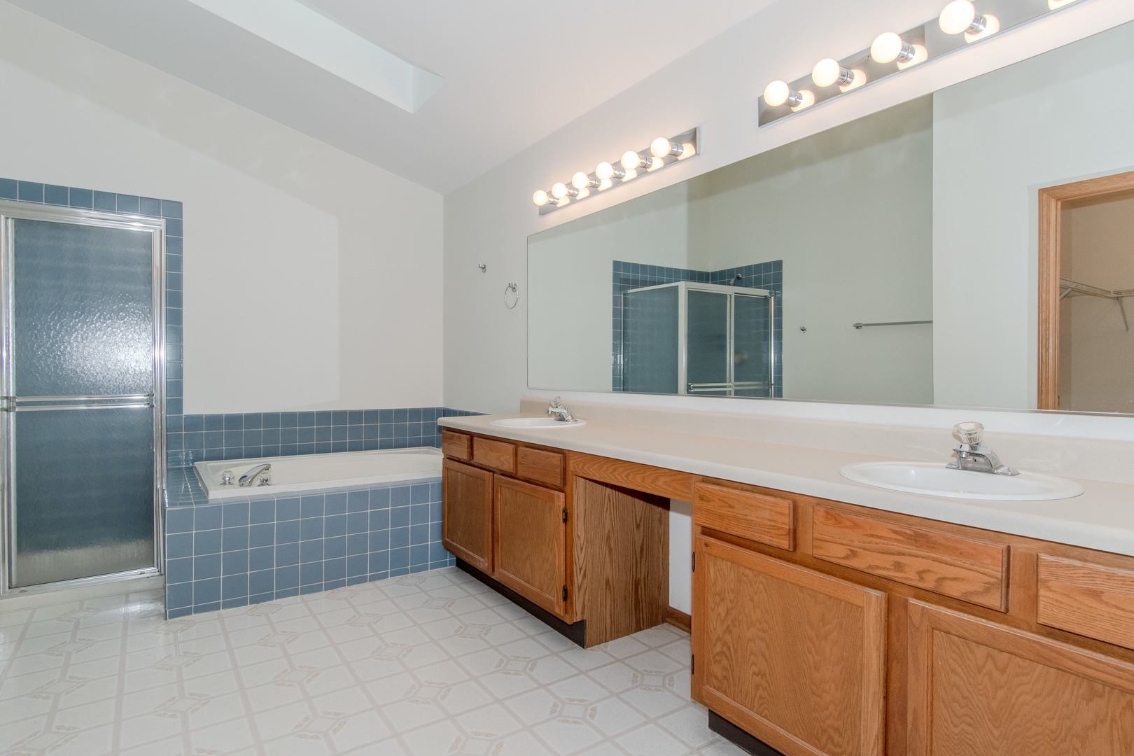 329 Sheffield Court, Unit 2 Roselle, IL 60172 - Photo 13 of 28 a spacious bathroom with a sink a large mirror and a bathtub