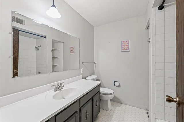 a bathroom with a granite countertop sink a toilet and a mirror