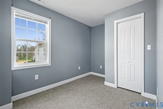 an empty room with windows and closet