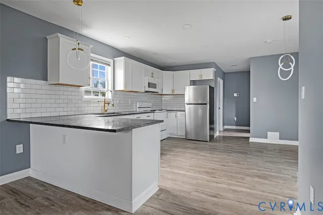 a kitchen with stainless steel appliances granite countertop a sink and a refrigerator