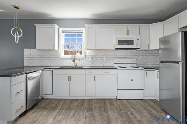a kitchen with granite countertop white cabinets white stainless steel appliances and sink