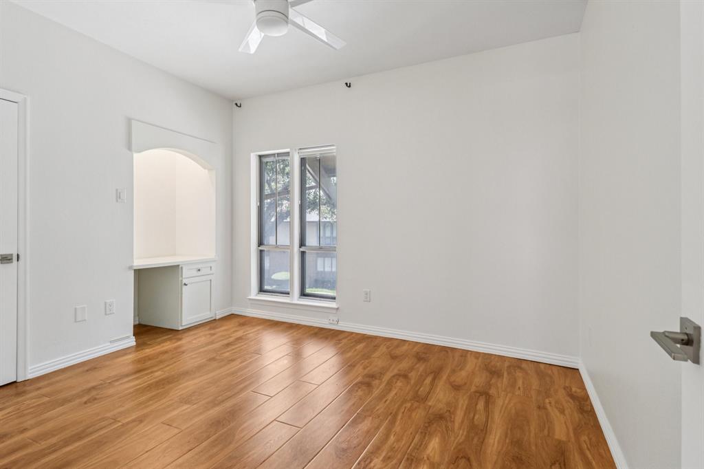 10754 Villager Road, Unit D Dallas, TX 75230 - Photo 21 of 37 an empty room with wooden floor and windows