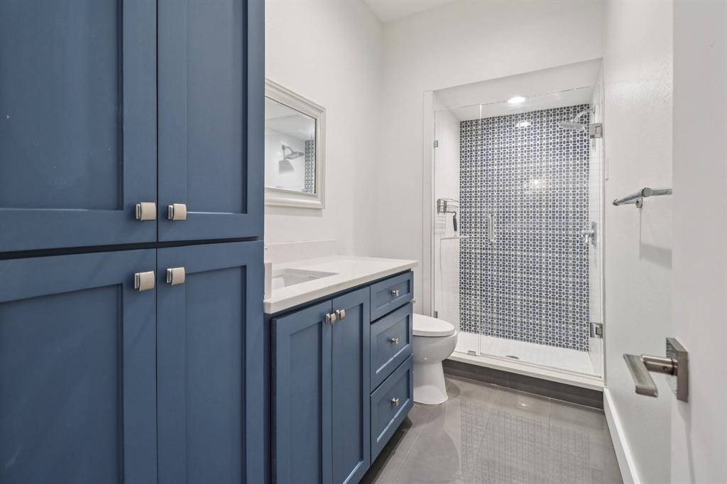 10754 Villager Road, Unit D Dallas, TX 75230 - Photo 22 of 37 a bathroom with a granite countertop sink a toilet and shower