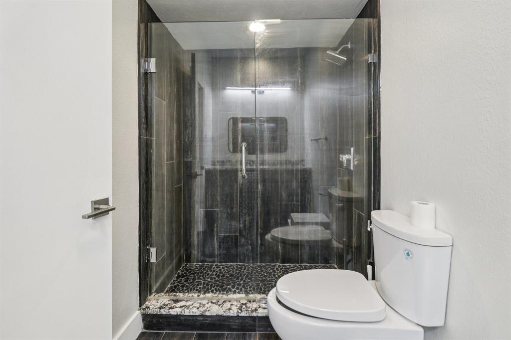 10754 Villager Road, Unit D Dallas, TX 75230 - Photo 23 of 37 a white toilet sitting next to a bathroom sink