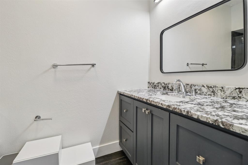 10754 Villager Road, Unit D Dallas, TX 75230 - Photo 26 of 37 a bathroom with a granite countertop sink and a mirror