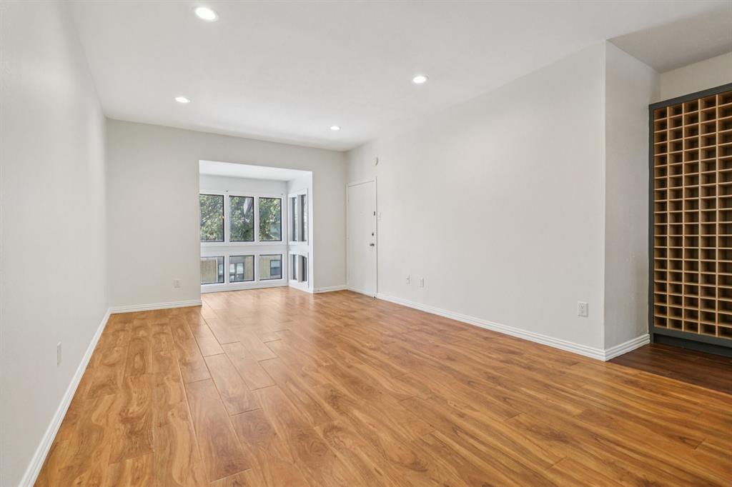 10754 Villager Road, Unit D Dallas, TX 75230 - Photo 32 of 37 a view of empty room with wooden floor and fan