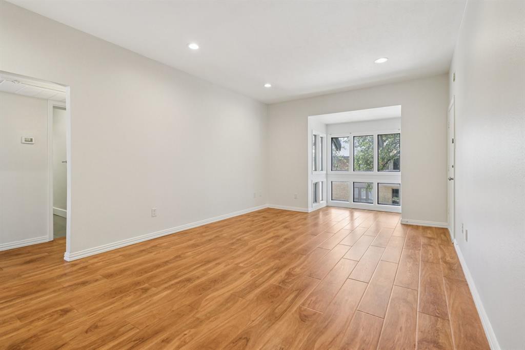 10754 Villager Road, Unit D Dallas, TX 75230 - Photo 33 of 37 a view of empty room with wooden floor and fan