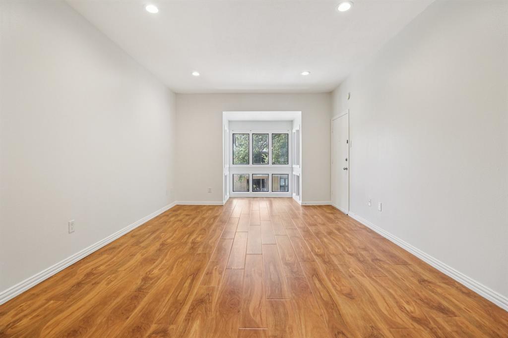 10754 Villager Road, Unit D Dallas, TX 75230 - Photo 34 of 37 a view of an empty room with wooden floor and a window