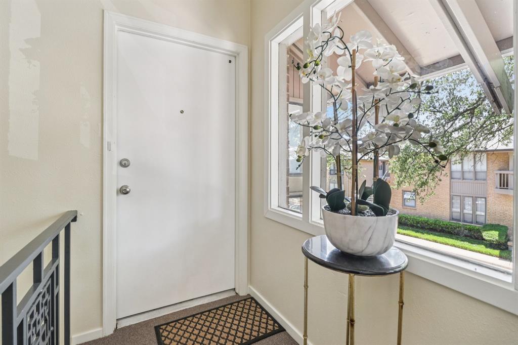 10754 Villager Road, Unit D Dallas, TX 75230 - Photo 35 of 37 a living room with a couch and a chandelier