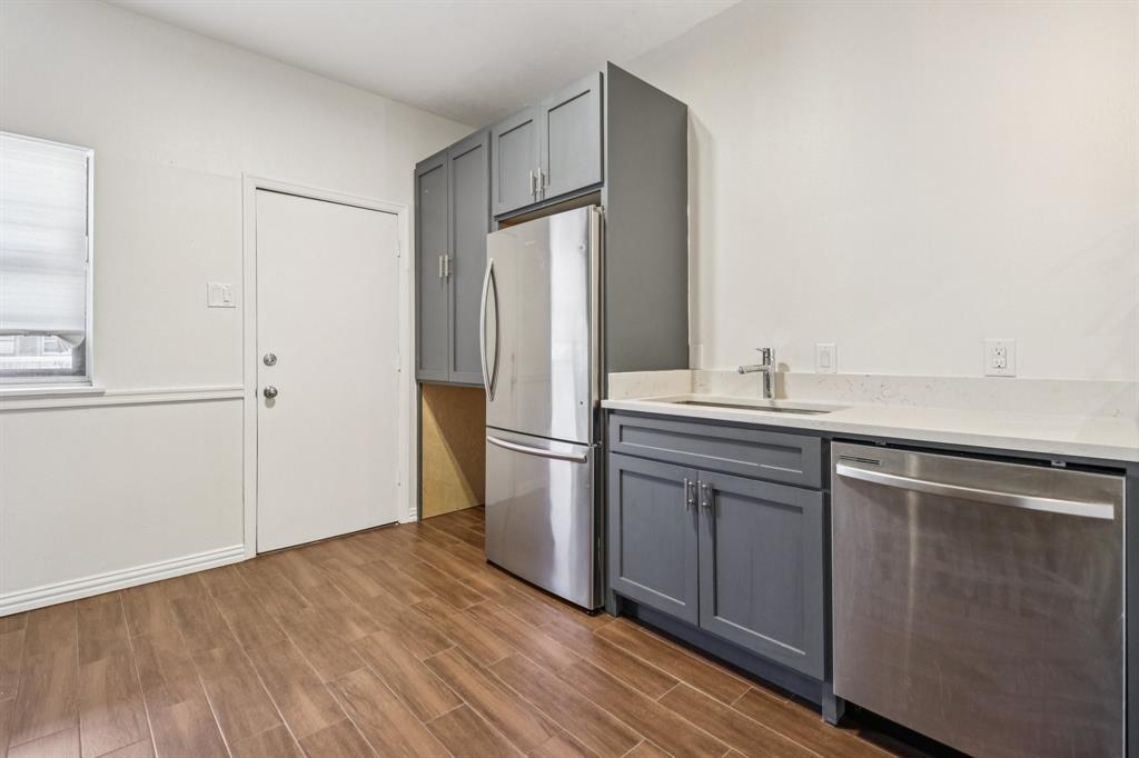 10754 Villager Road, Unit D Dallas, TX 75230 - Photo 6 of 37 a kitchen with a refrigerator sink and cabinets