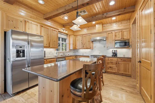 a large kitchen with stainless steel appliances granite countertop a stove a sink and a refrigerator