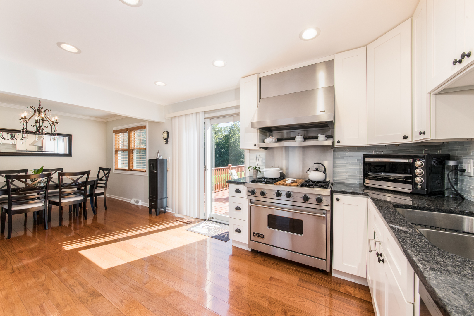 213 Forest View Drive Lake Bluff, IL 60044 - Photo 10 of 37 a kitchen with stainless steel appliances granite countertop a stove top oven a sink dishwasher a dining table and chairs with wooden floor