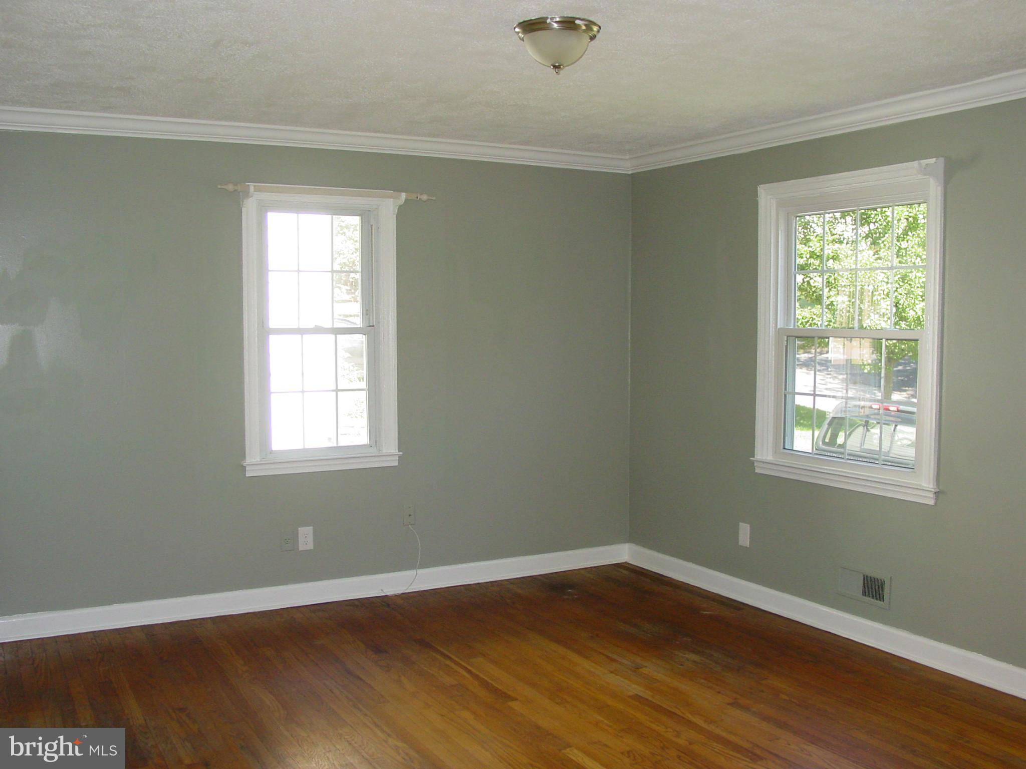 7912 Ridgely Oak Road Baltimore, MD 21234 - Photo 3 of 20 an empty room with wooden floor and windows
