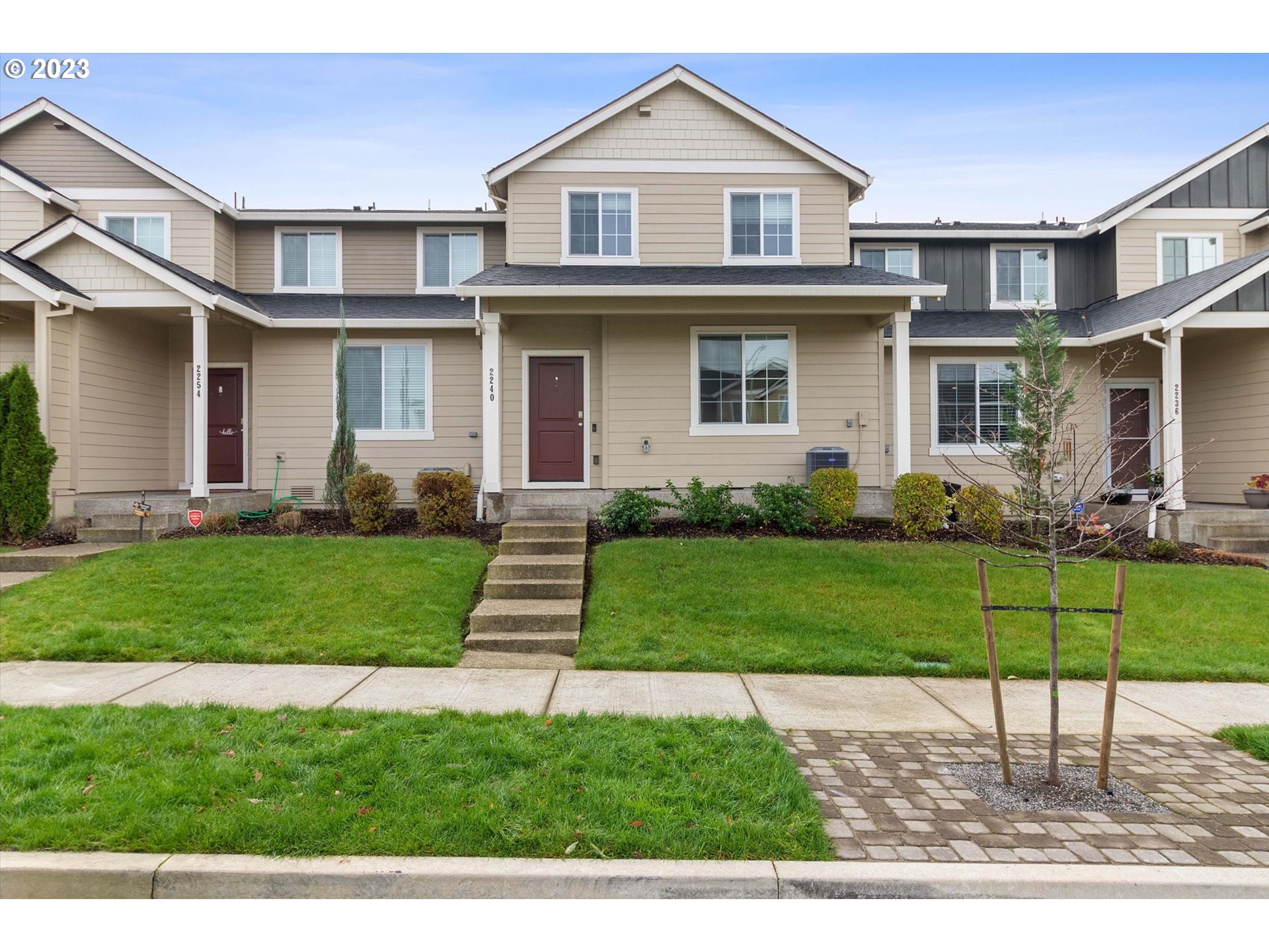 a front view of a house with a yard and trees