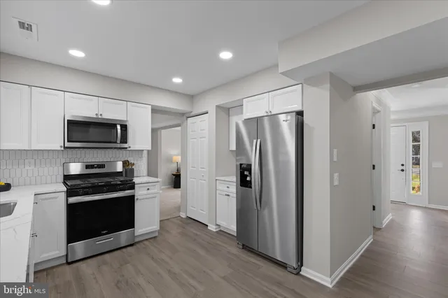 a kitchen with stainless steel appliances granite countertop a refrigerator and a stove top oven