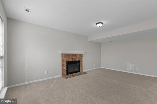 an empty room with a fireplace and fan