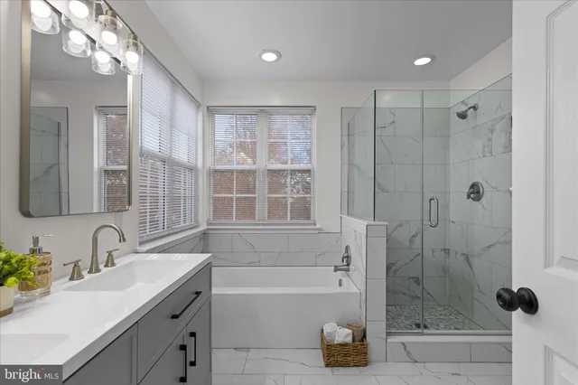 a bathroom with a tub sink shower and a mirror