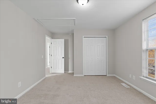 an empty room with windows and closet