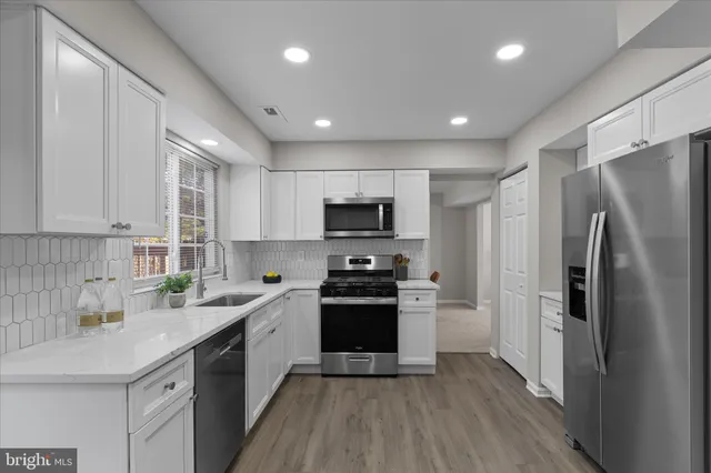 a kitchen with stainless steel appliances a refrigerator sink and stove