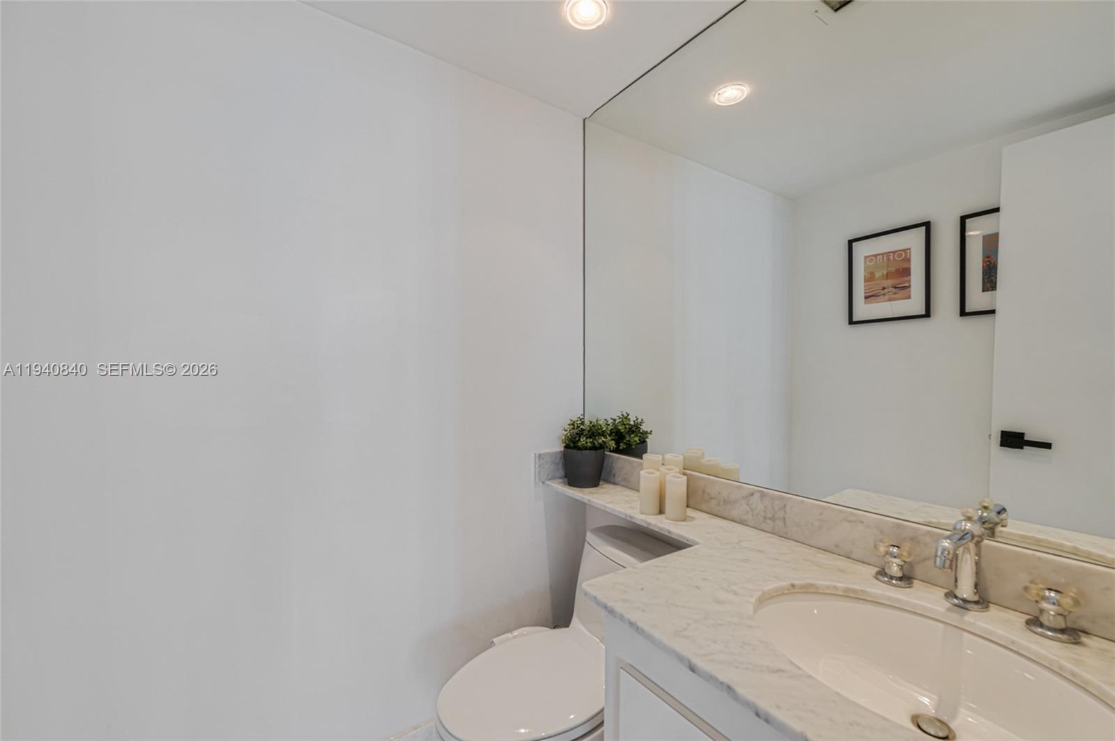 600 Northeast 36th Street, Unit PH1 Miami, FL 33137 - Photo 6 of 41 a bathroom with a toilet sink and mirror