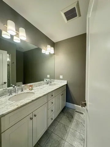 a spacious bathroom with a double vanity sink and a mirror