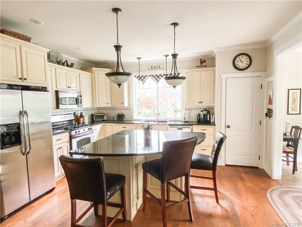 569 Golf Course Road Clyde, NC 28721 - Photo 22 of 39 a kitchen with stainless steel appliances granite countertop a dining table chairs sink and cabinets