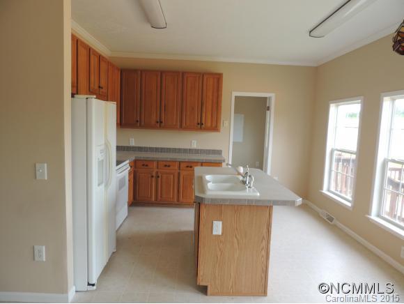 131 Timber Ridge Rutherfordton, NC 28139 - Photo 3 of 11 a kitchen with kitchen island granite countertop a refrigerator and a sink