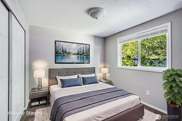 a bedroom with a large bed and a potted plant