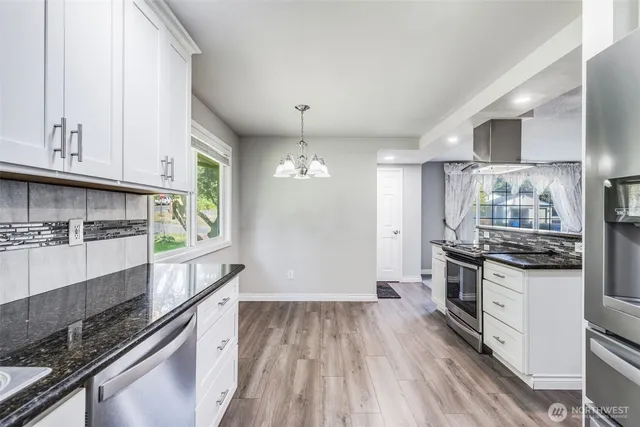 a kitchen with stainless steel appliances granite countertop a stove and a sink