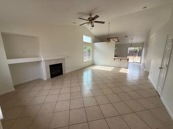 a view of an empty room and a kitchen
