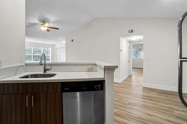 a kitchen with a sink cabinets and wooden floor