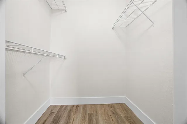 a view of walk in closet with wooden floor