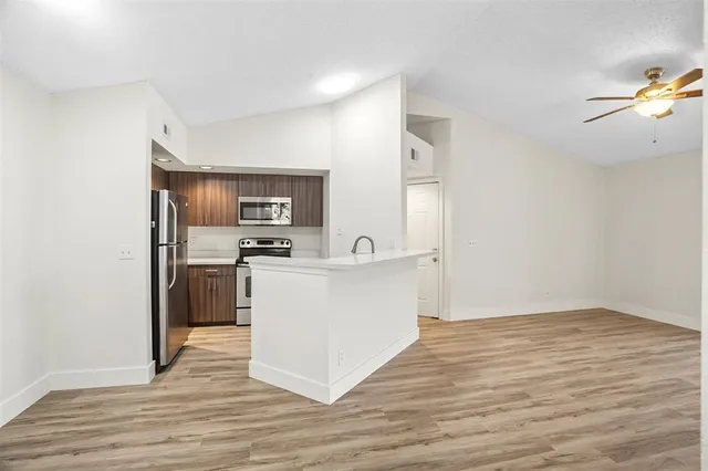 a view of kitchen with sink microwave and refrigerator