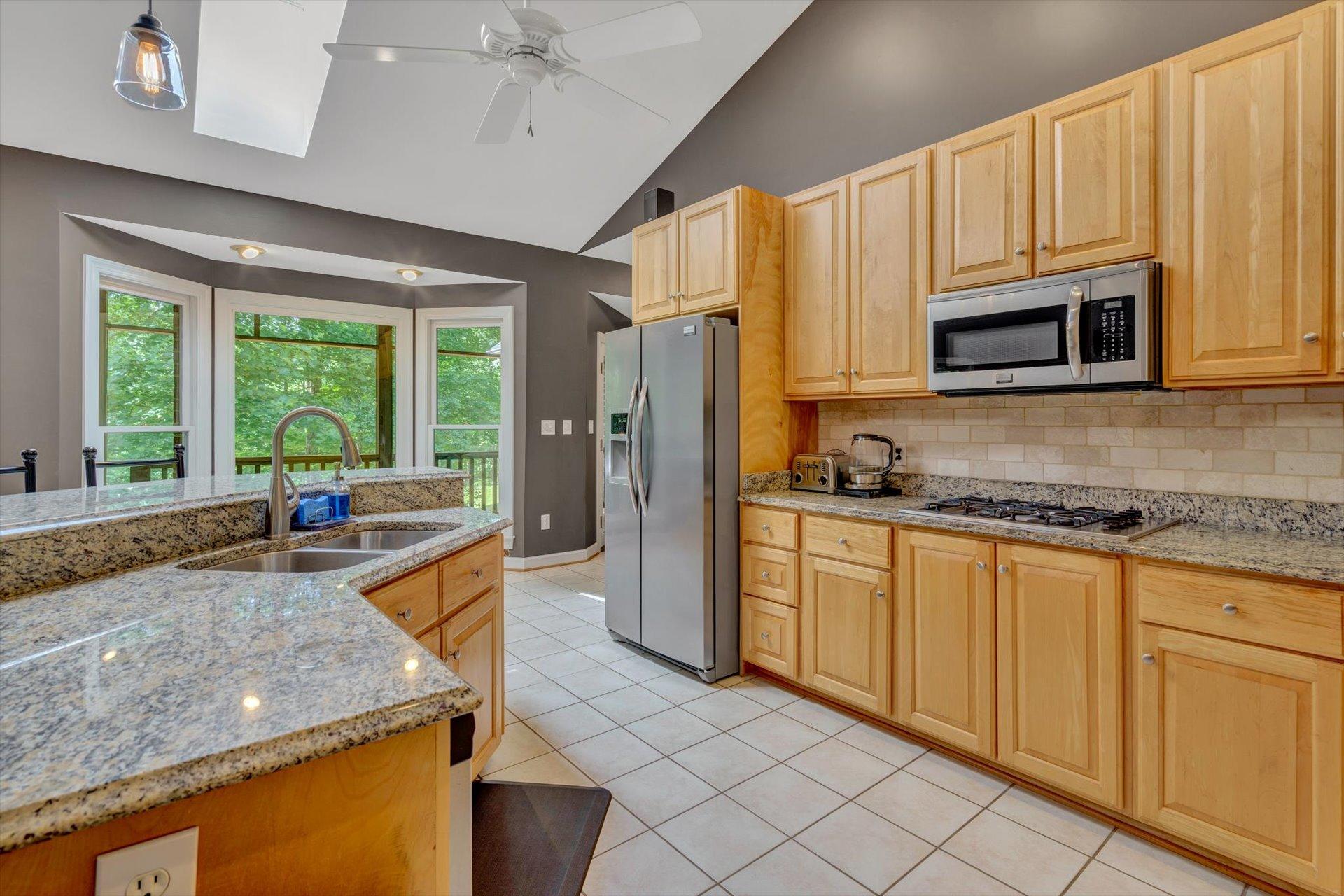 2795 New Ridge Road Elliston, VA 24087 - Photo 17 of 46 a kitchen with stainless steel appliances granite countertop a stove a sink and a microwave