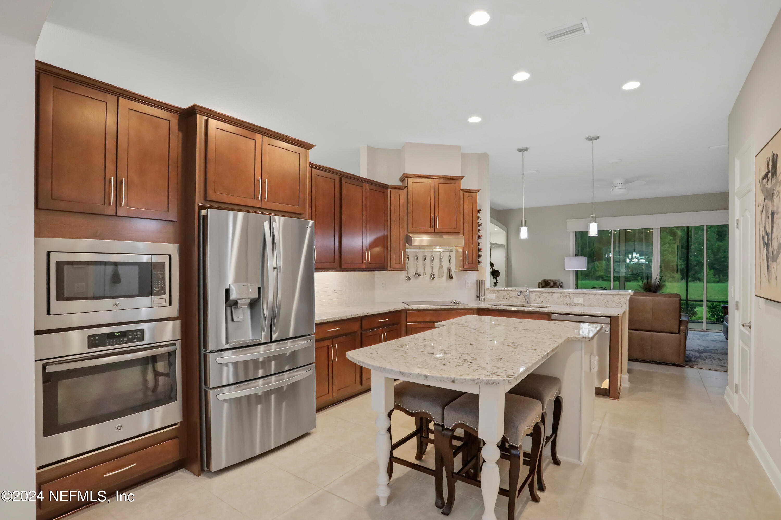 183 Flora Lake Circle St. Augustine, FL 32095 - Photo 20 of 40 a kitchen with granite countertop a refrigerator stove top oven dining table and chairs