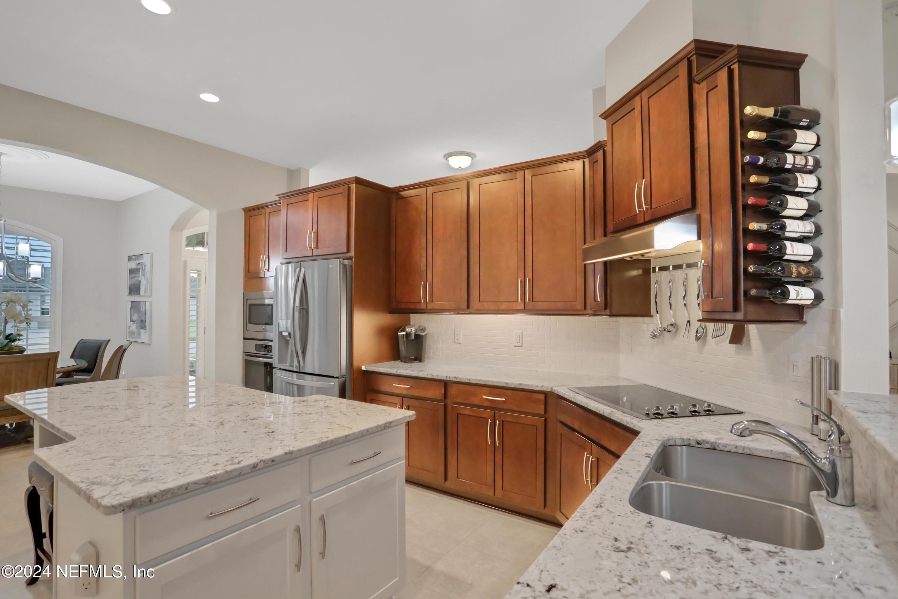 183 Flora Lake Circle St. Augustine, FL 32095 - Photo 22 of 40 a kitchen with stainless steel appliances granite countertop a sink dishwasher stove and refrigerator with wooden floor
