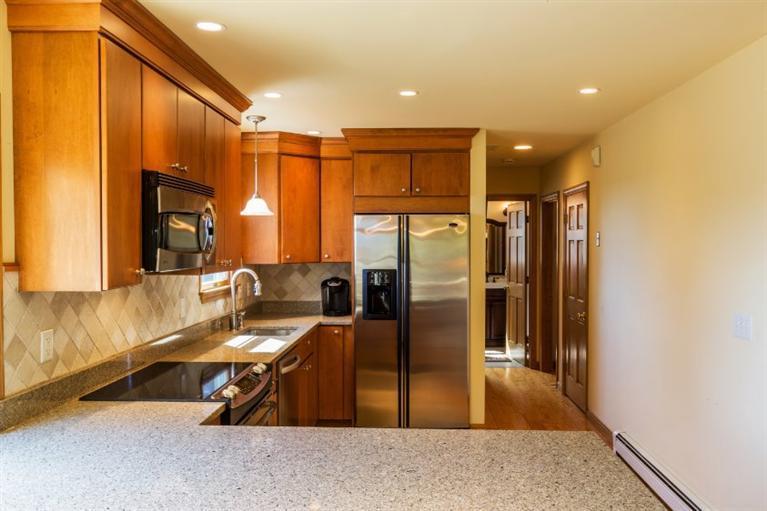 13 Snows Road Truro, MA 02666 - Photo 8 of 28 a kitchen with stainless steel appliances granite countertop a refrigerator a stove and a sink with wooden floor