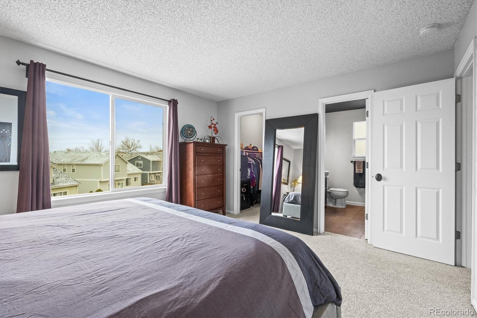 951 Timbervale Trail Highlands Ranch, CO 80129 - Photo 13 of 33 a bedroom with a large bed and a large window