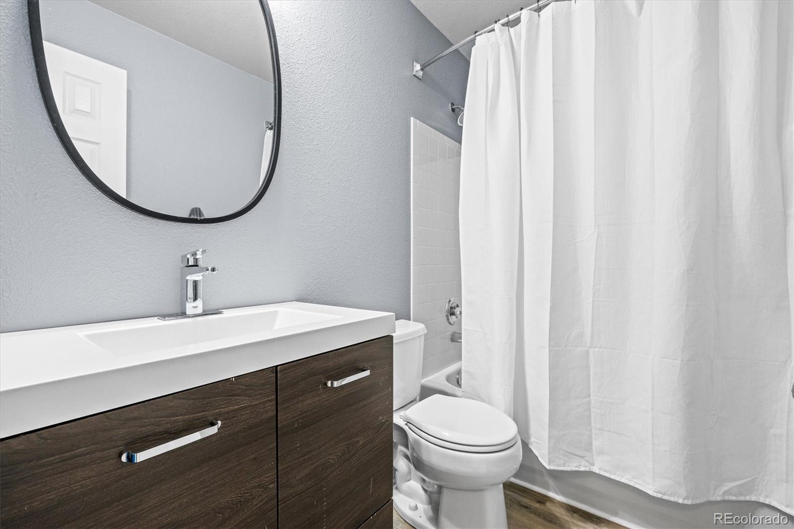 951 Timbervale Trail Highlands Ranch, CO 80129 - Photo 19 of 33 a bathroom with a sink a toilet and a mirror