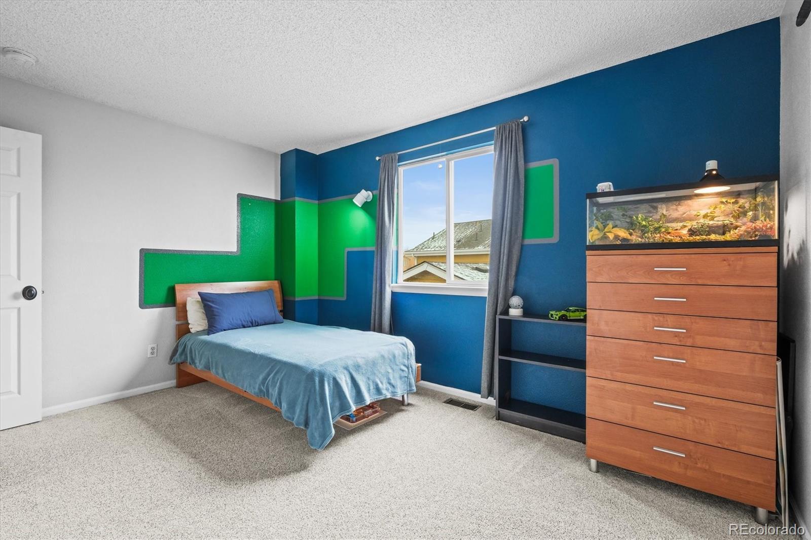 951 Timbervale Trail Highlands Ranch, CO 80129 - Photo 21 of 33 a bedroom with a bed and a dresser