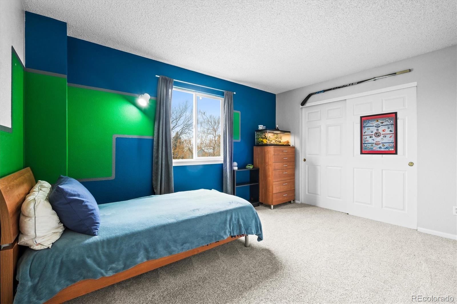 951 Timbervale Trail Highlands Ranch, CO 80129 - Photo 22 of 33 a bedroom with a bed painting on wall and a large window
