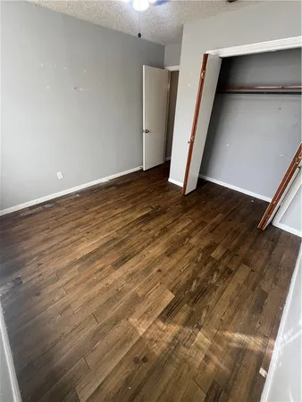 an empty room with wooden floor and stairs