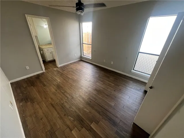 wooden floor in an empty room with a window