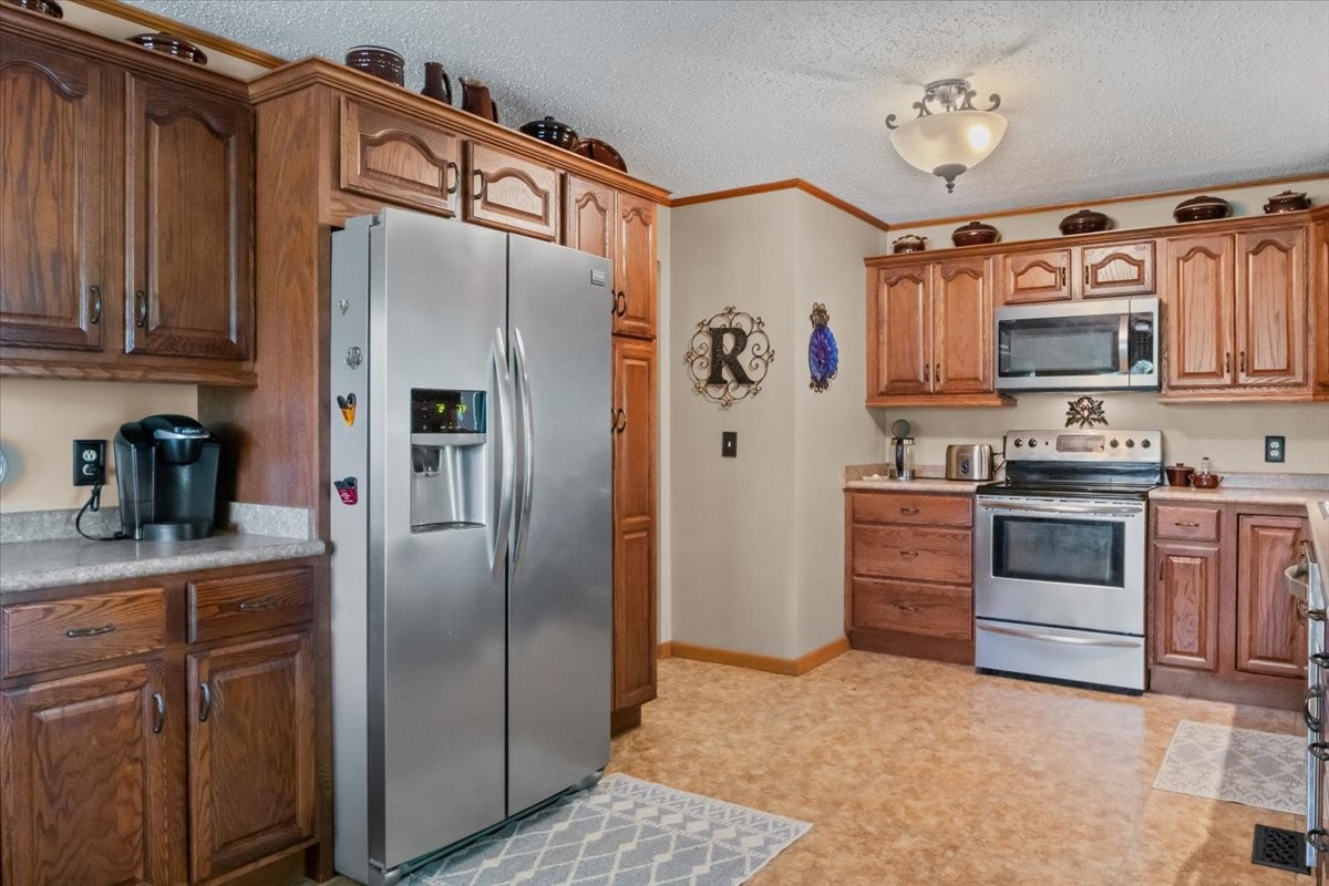 48 Hill Road Big Sandy, TN 38221 - Photo 11 of 54 a kitchen with granite countertop a refrigerator stove and sink