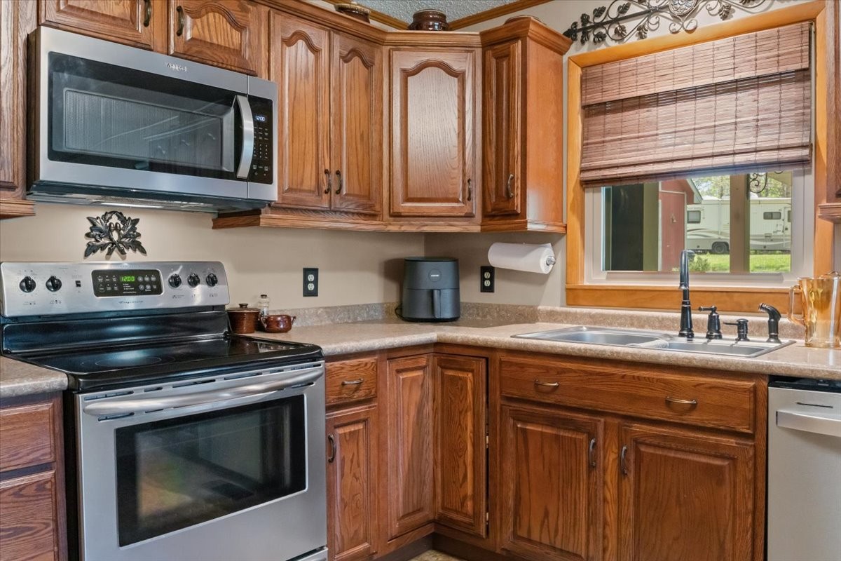 48 Hill Road Big Sandy, TN 38221 - Photo 12 of 54 a kitchen with granite countertop a stove sink and microwave