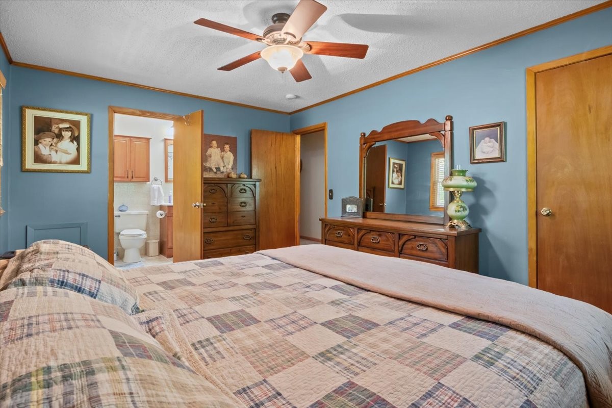 48 Hill Road Big Sandy, TN 38221 - Photo 15 of 54 a bedroom with a large bed and a chandelier